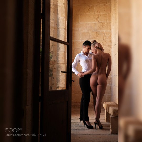 Naked woman dancing with clothed woman